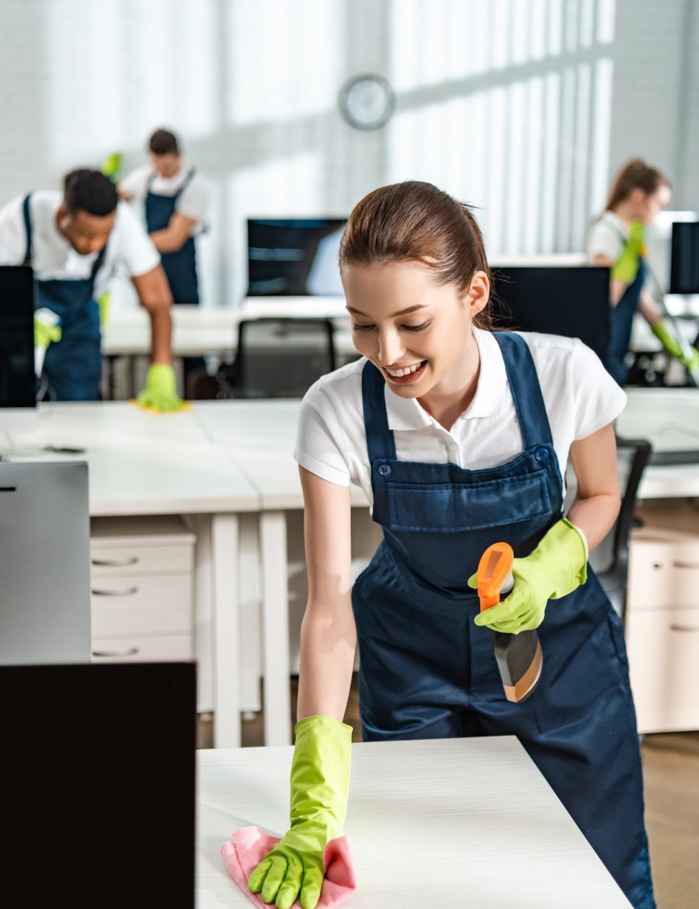 cheerful-cleaner-in-overalls-cleaning-office-desk-with-rag.jpg cheerful-cleaner-in-overalls-cleaning-office-desk-with-rag.jpg